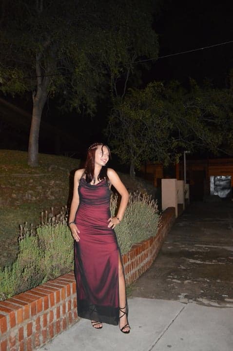 Joven sonriente posando en la entrada del salón
