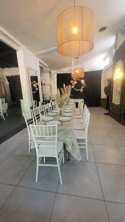 Salón interior con mesas blancas y lámparas de yute