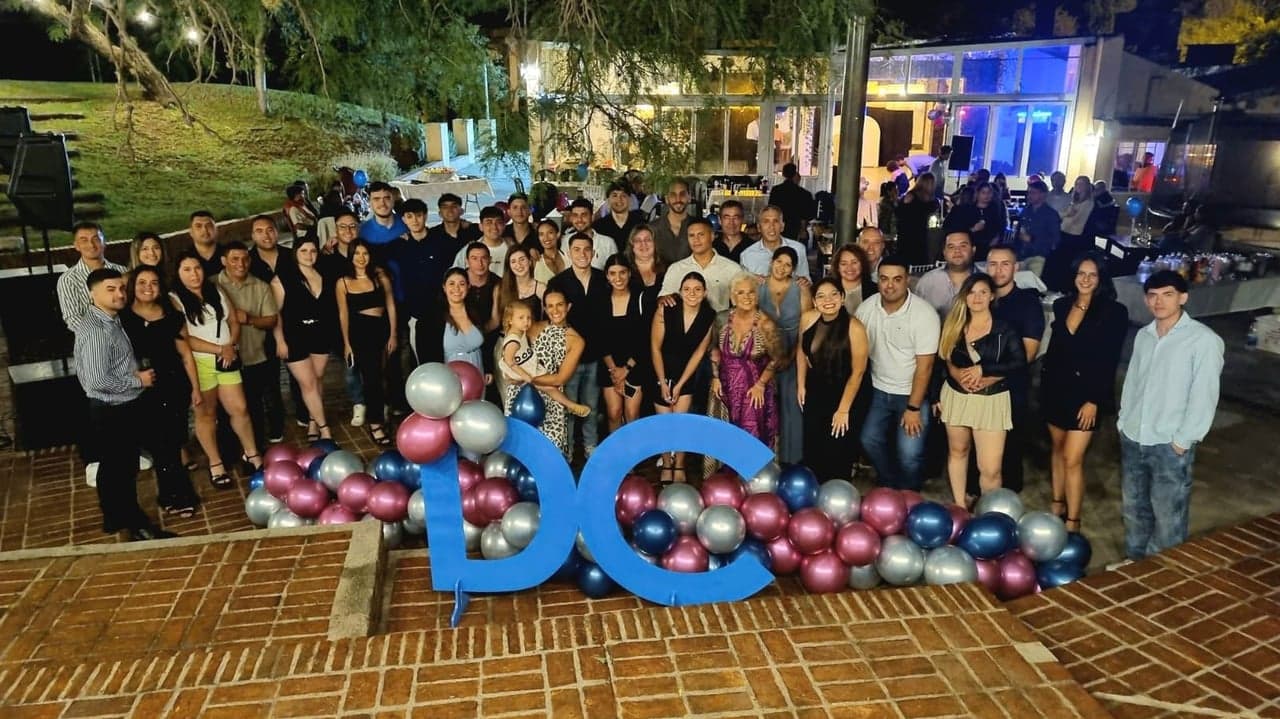 Foto grupal de egresados con globos y letras decorativas